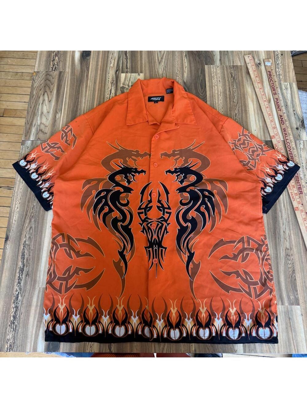 Orange Amplify button-up shirt with black tribal dragon design and flame motifs,